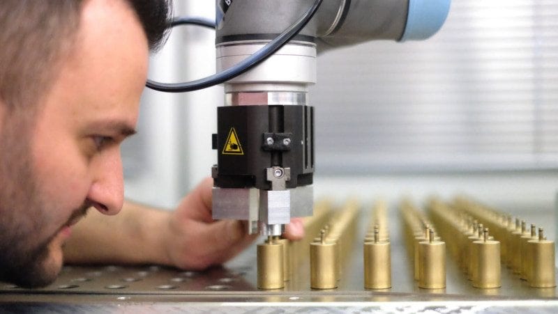 Nahaufnahme eines Mannes, der Metallobjekte mit einem Cobot Präzisionsgreifer einrichtet