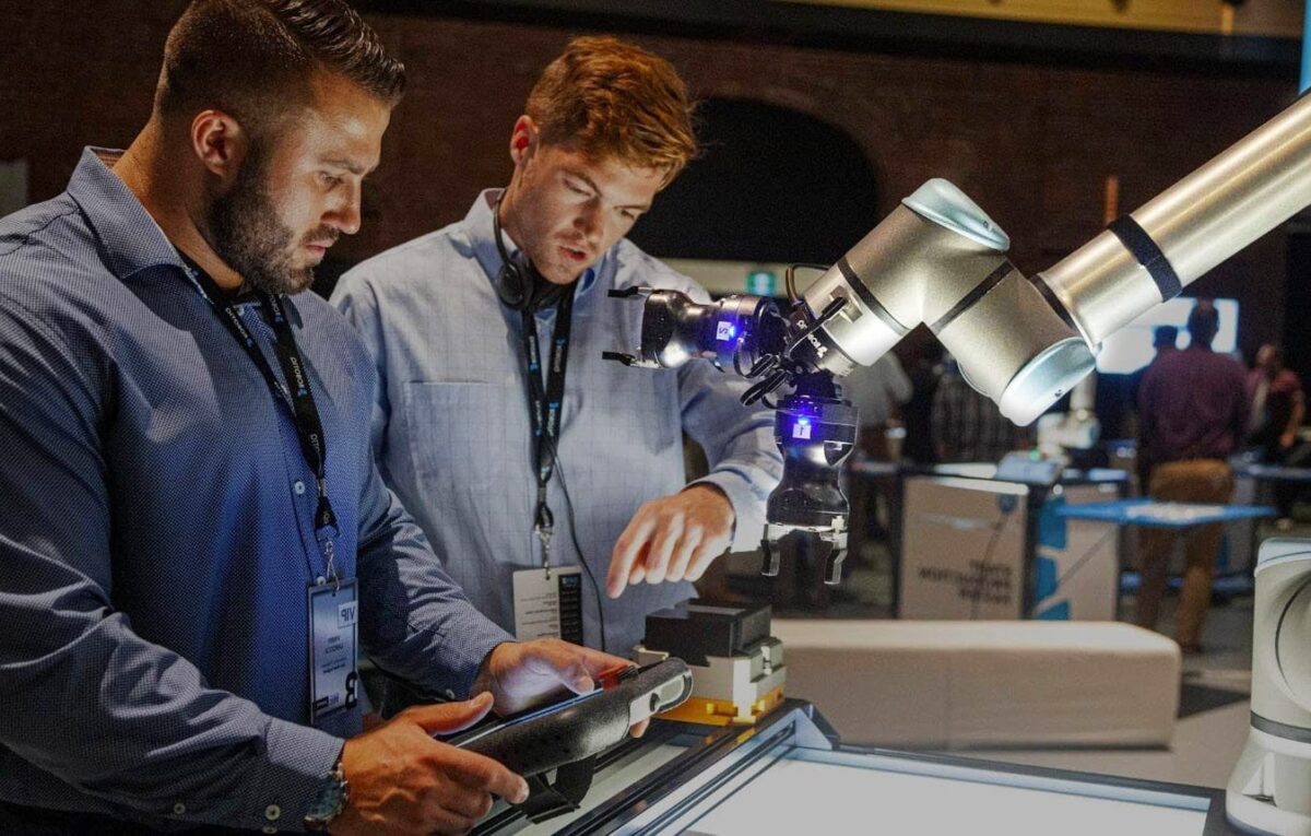 Zwei Männer arbeiten mit einem Cobot von Universal Robots