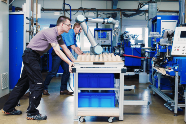 Mann bedient ein Tablet neben einem Cobot