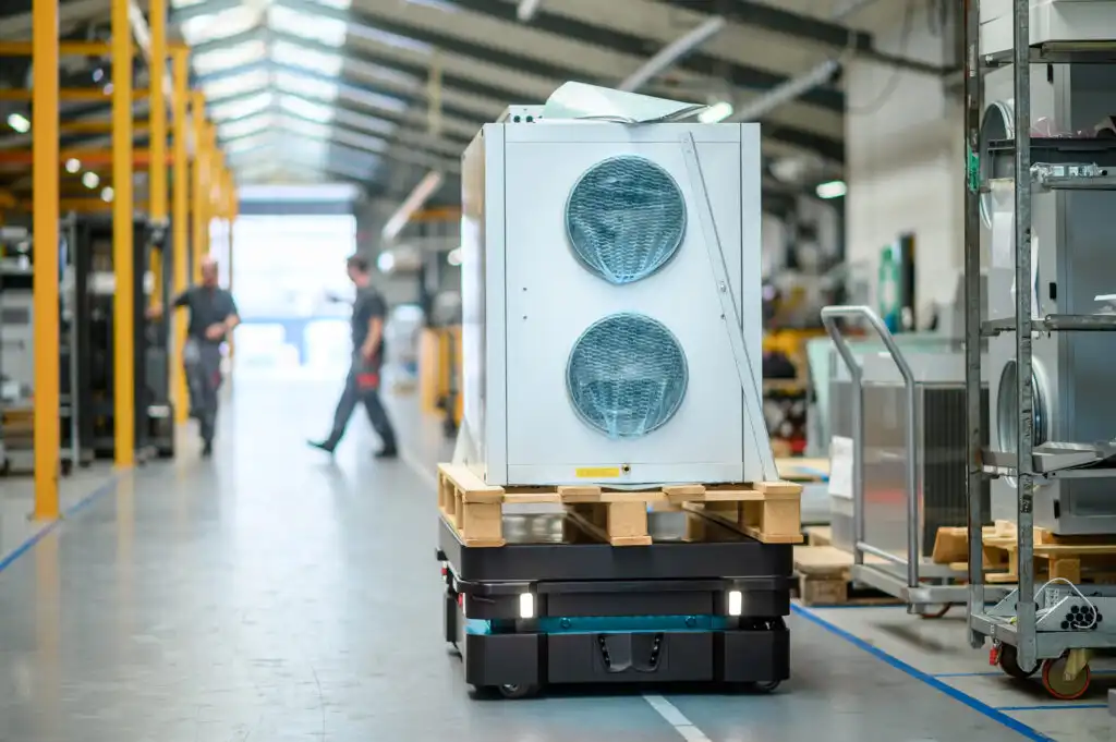ein autonomer mobiler roboter (amr) transportiert eine weisse box auf einem palett.